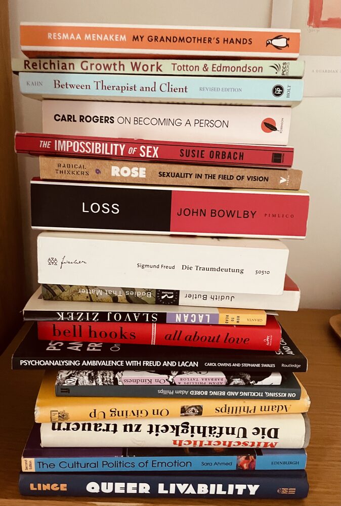 A pile of books on psychotherapy, psychoanalysis and culture, including works by Carl Rogers, John Bowlby, Sigmund Freud, Adam Phillips, bell hooks and Sara Ahmed